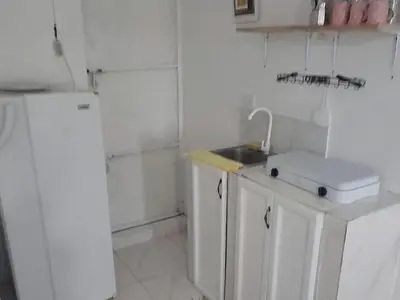 a white kitchen with a sink and a refrigerator at Apartamento Los Blancos, a dos Minutos de los Patos Barahona in Enriquillo