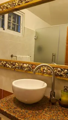 a bathroom with a white sink and a mirror at Tritón Hotel Boutique & Restaurant in Guayacanes