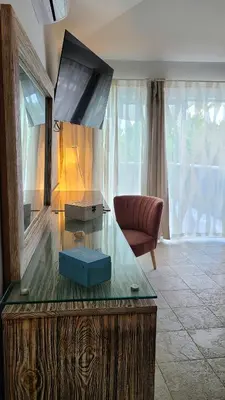 a living room with a glass table with a tv on it at Tritón Hotel Boutique & Restaurant in Guayacanes