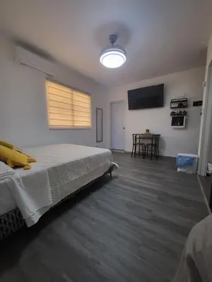 a bedroom with a bed and a flat screen tv at La casita de Gazcue in Santo Domingo