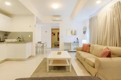 a living room with a couch and a table at Escape Apartments, Balcony, Pool & Gym in La Julia in Santo Domingo