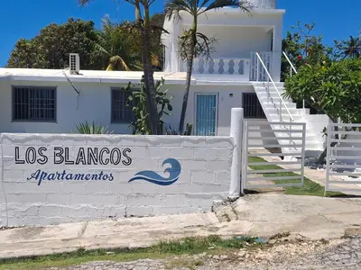 a white house with a sign that reads los blancos apartments at Apto Los Blancos, a dos Minuto de los Patos in Bejuquero
