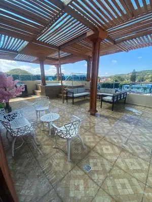 a patio with tables and chairs on a roof at Cozy Apartment RM in Santiago de los Caballeros