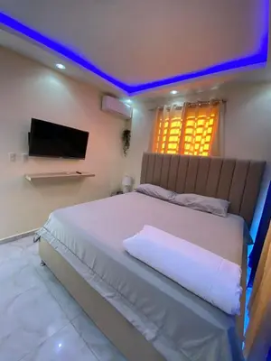 a bedroom with a large white bed with a tv at Cozy Apartment RM in Santiago de los Caballeros