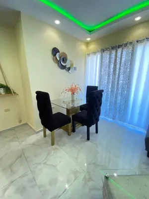 a dining room with a glass table and black chairs at Cozy Apartment RM in Santiago de los Caballeros