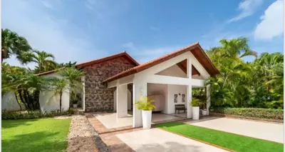 a house with a green lawn in front of it at Lux Villa Casa de Campo in La Romana