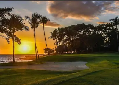 a golf course with palm trees and the ocean at sunset at Lux Villa Casa de Campo in La Romana