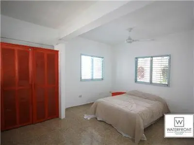 a bedroom with a bed and a red cabinet at Bungalow #1 at Waterfront Playa Alicia in Sosúa