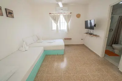 a room with a couch and a tv and a toilet at Bungalow #15 at Waterfront Playa Alicia in Sosúa