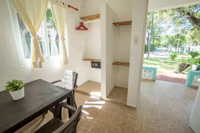 a dining room with a table and chairs and a window at Bungalow #15 at Waterfront Playa Alicia in Sosúa