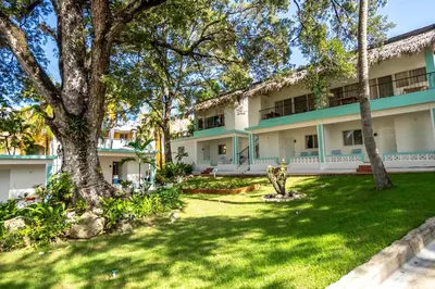 an exterior view of a building with a green yard at Room #24 at Waterfront Playa Alicia in Sosúa