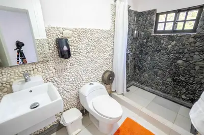 a bathroom with a white toilet and a sink at Room #24 at Waterfront Playa Alicia in Sosúa