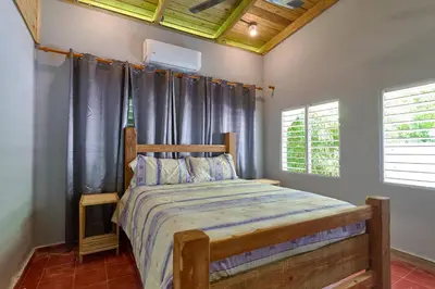 a bedroom with a bed with a wooden head board at Casa Kafe in Cabrera