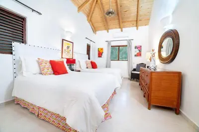 two beds in a bedroom with a mirror and a dresser at Los Lagos 19 - Sleeps 10 - Butler - Pool Hot Tub in La Romana