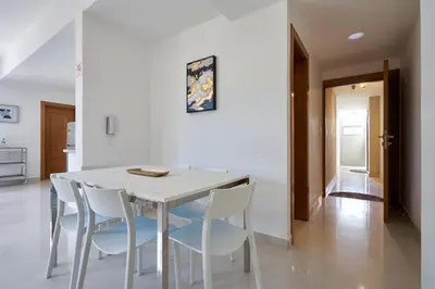 a white dining room with a white table and white chairs at Apartments in La Julia 1 and 2 Bedrooms in Santo Domingo