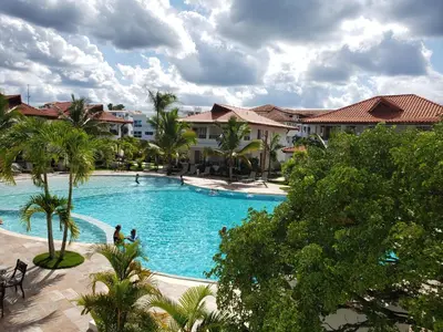 a large swimming pool in a resort with palm trees at Residencial Paraiso Bayahibe in Bayahibe