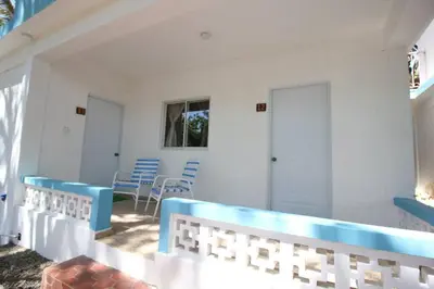 a patio with blue and white benches and chairs at Bungalow #12 at Waterfront Playa Alicia in Sosúa