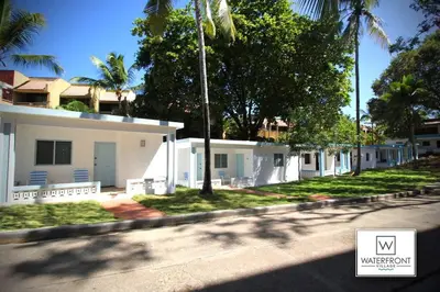 a street with a white house and palm trees at Bungalow #12 at Waterfront Playa Alicia in Sosúa