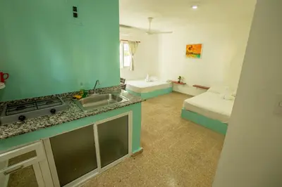 a kitchen with a sink and a bed in a room at Bungalow #14 at Waterfront Playa Alicia in Sosúa