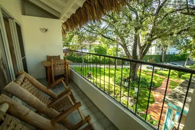 a balcony with chairs and a view of a yard at Bungalow #17 at Waterfront Playa Alicia in Sosúa