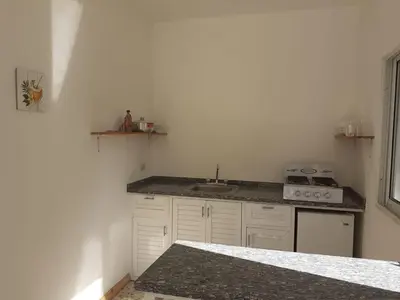 a white kitchen with a sink and a stove at Apartment #21 at Waterfront Playa Alicia in Sosúa