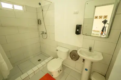 a white bathroom with a toilet and a sink at Bungalow #4 at Waterfront Playa Alicia in Sosúa