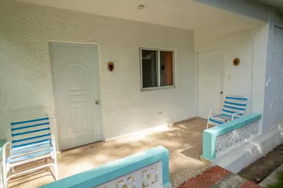 two chairs sitting on the porch of a house at Bungalow #4 at Waterfront Playa Alicia in Sosúa