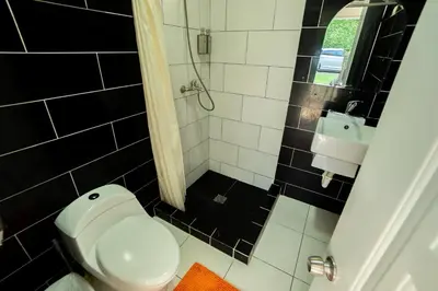 a black and white bathroom with a toilet and a sink at Bungalow #6 at Waterfront Playa Alicia in Sosúa