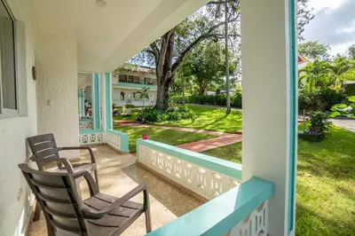 a porch with chairs and a view of a yard at Bungalow #9 at Waterfront Playa Alicia in Sosúa
