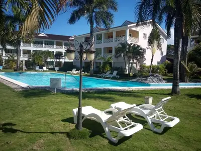 two white lounge chairs next to a swimming pool at Playa Turquesa only 50m From the Beach Walk to all Restaurants in Las Terrenas