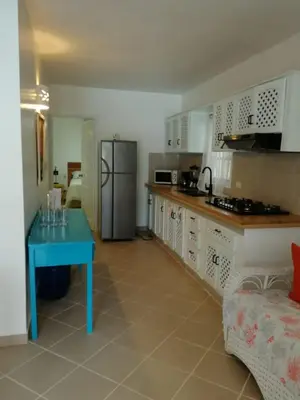 a kitchen with a blue table and a refrigerator at Playa Turquesa only 50m From the Beach Walk to all Restaurants in Las Terrenas