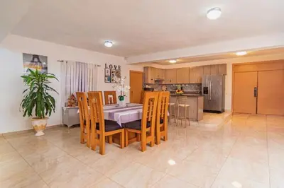 a kitchen and dining room with a table and chairs at Villa Nilsa ( The Blue House ) in Baní