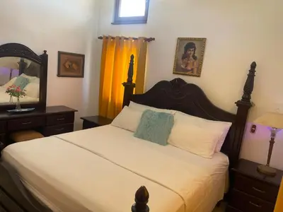 a bedroom with a large bed and a mirror at Ocean Breeze Villa Carismar in Cabrera