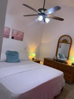 a bedroom with a white bed and a ceiling fan at Ocean Breeze Villa Carismar in Cabrera