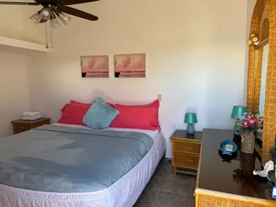 a bedroom with a bed with red and blue pillows at Ocean Breeze Villa Carismar in Cabrera