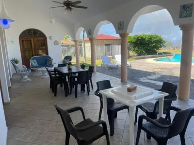 a patio with tables and chairs and a pool at Ocean Breeze Villa Carismar in Cabrera