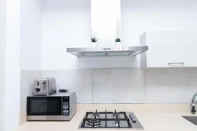 a white kitchen with a microwave and a stove at S1401 La mejor vista Downtown Santo Domingo RD in Santo Domingo