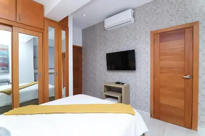 a bedroom with a bed and a tv on a wall at S1401 La mejor vista Downtown Santo Domingo RD in Santo Domingo