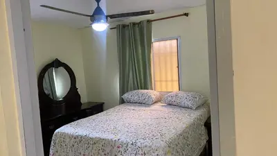 a bedroom with a bed with a dresser and a mirror at TriRoom Apartment SANTO DOMINGO ESTE in Santo Domingo