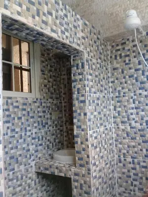 a bathroom with a tiled wall with a window at Villa Julirous Rd 2 bedrooms apartment in Boca Chica