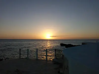 a sunset over the ocean with the sun setting at Estudio Frente al Mar Solo Adultos in La Laguna