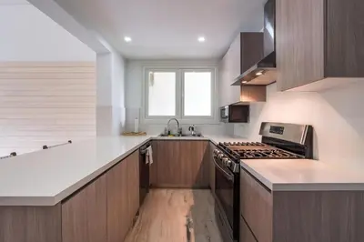 a kitchen with wooden cabinets and a stove top oven at Newly Added El Portillo 2BR Apt in Abra Grande