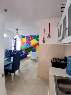 a kitchen and living room with a colorful wall at Villa Boutique con Piscina Privada a Minutos del Aeropuerto SDQ in Boca Chica