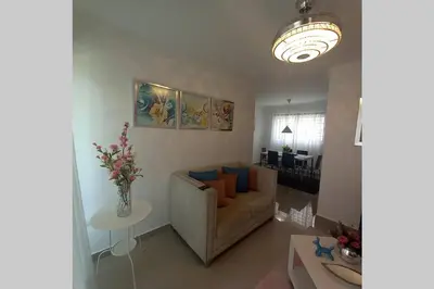 a living room with a couch and a table at Confortable apartamento de 3 tres habitaciones, con hermosa vista de area verde, ademas de piscinas y juegos infantiles en area recreativa in Santiago de los Caballeros