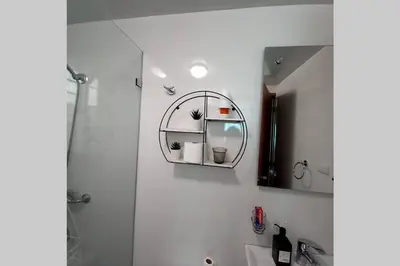 a bathroom with a shower and a sink and a mirror at Confortable apartamento de 3 tres habitaciones, con hermosa vista de area verde, ademas de piscinas y juegos infantiles en area recreativa in Santiago de los Caballeros