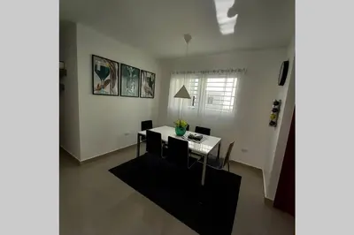 a dining room with a table and chairs in a room at Confortable apartamento de 3 tres habitaciones, con hermosa vista de area verde, ademas de piscinas y juegos infantiles en area recreativa in Santiago de los Caballeros