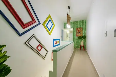 a hallway with paintings on the wall and a staircase at Bamboo Hoouse in Santo Domingo