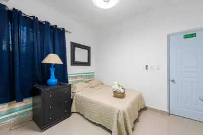 a bedroom with a bed and a lamp on a dresser at Bamboo Hoouse in Santo Domingo