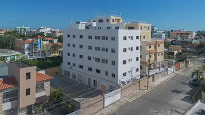 a tall white building in a city with buildings at 2 Bedroom-Apartment - Corales del Sur Ole Las Americas- Isabelita - Aeropuerto in La Viva