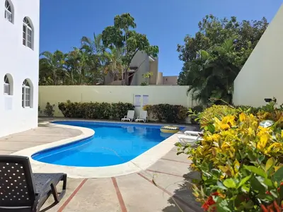 a swimming pool in the middle of a yard at Costambar Beach Seaside Apartment in San Felipe de Puerto Plata